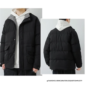 Detail view of men's thick black winter jacket featuring houndstooth lining and pockets