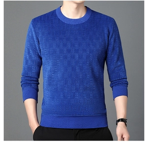 Détail du pull en chenille bleue montrant la maille damier et les poignets côtelés