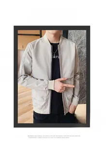 Détail de veste bomber beige clair avec col côtelé et fermeture éclair minimaliste