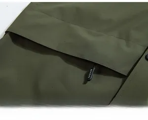 Detailed macro view of olive green hooded jacket featuring a hidden zip pocket for security