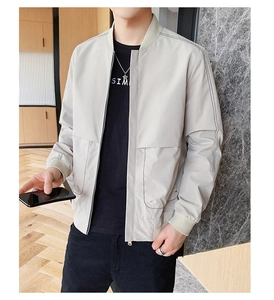 Gros plan du col côtelé et des coutures sur une veste bomber beige pour homme