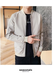 Détail d'un blouson bomber beige avec surpiqûres noires et col baseball côtelé