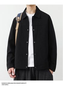 Close-up of black waffle texture jacket with metal snap buttons and minimalist collar