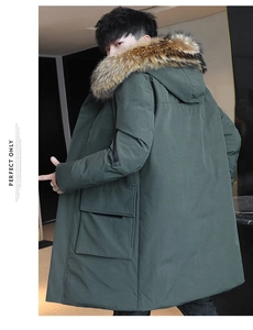 Detail view of winter parka featuring lush faux fur hood and deep green quilted fabric