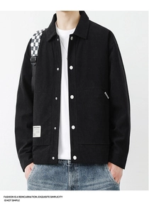 Detailed view of black corduroy men's jacket featuring silver metal buttons and lapel