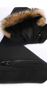 Detail view of the detachable brown faux fur hood and sleeve zipper on a black winter parka
