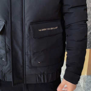 Men's black padded winter jacket with yellow embroidery detail and ribbed cuffs