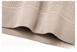 Détail de l'ourlet côtelé et de la maille texturée d'un pull en chenille chaud pour homme
