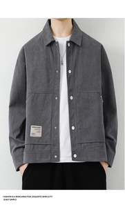 Close-up of men's dark grey corduroy jacket with silver buttons and brand label detail