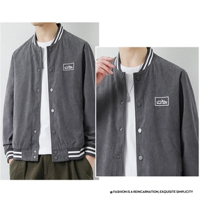 Detail of grey corduroy baseball jacket with striped ribbing and mountain logo patch
