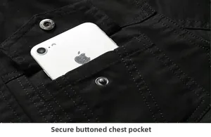 Close-up of black cotton work jacket showing a secure buttoned chest pocket with a phone