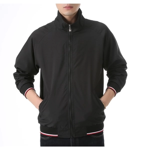 Detail of tricolor striped ribbed cuffs and hem on a black men's zip-up baseball jacket