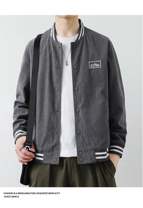 Detail of grey corduroy baseball jacket showing mountain embroidery and ribbed collar