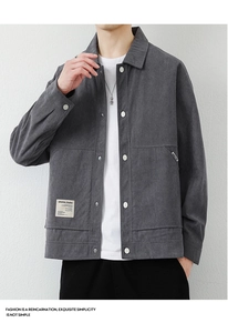 Detailed view of dark grey corduroy jacket texture with pockets and branded logo patch