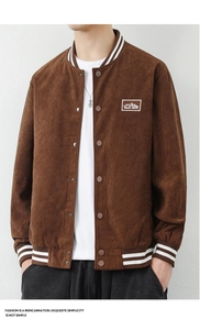 Detail of dark brown corduroy bomber jacket featuring embroidered mountain chest patch