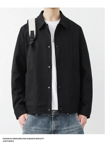 Detail der minimalistischen schwarzen Baumwolljacke mit klassischem Kragen und Druckknöpfen
