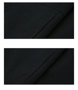 Detail of black fabric with honeycomb texture and precision stitching on jacket