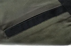 Detailed macro view of an olive green cotton jacket showing the functional inner pocket