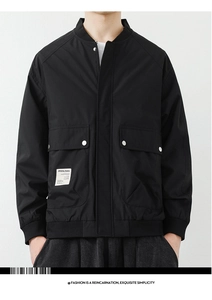 Detail of black workwear jacket with metal zip and utilitarian flap pockets on front