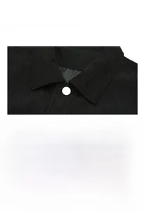 Detail view of black corduroy jacket with white buttons and textured vertical ribbed fabric