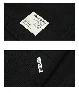 Detailed view of black corduroy fabric texture and stitched brand label on casual jacket