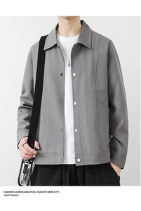 Detailaufnahme der grauen Herrenjacke mit strukturiertem Stoff und silbernen Metalldruckknöpfen