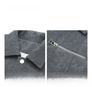 Close-up of grey corduroy jacket texture featuring metal zipper and silver button detail