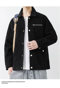 Detail of black corduroy jacket fabric with metal buttons and chest zipper pocket