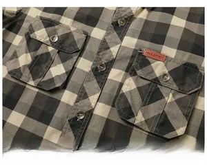 Detail of plaid cotton shirt showing chest pocket and brown leather label with text
