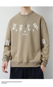 Detail of light brown oversized sweatshirt with white gothic lettering and star pattern