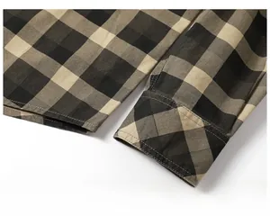 Detailed macro view of the checkered cotton shirt cuff showing fine stitching and brown pattern