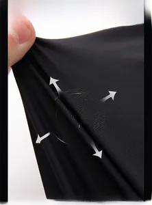 Gros plan sur un tissu en soie glacée noire extensible montrant la texture côtelée fine
