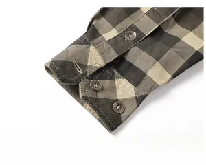 Detail of plaid cotton shirt sleeve with metal buttons engraved with Free Spirit text
