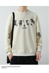 Close-up of gothic font print and star patterns on off-white long-sleeved sweatshirt
