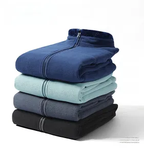 Detail of stacked men's fleece jackets showing navy, bean green, grey, and black colors