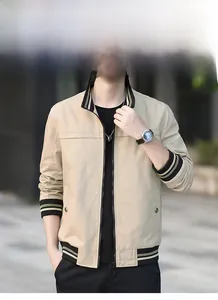 Détail du col en tricot rayé et de la fermeture éclair d'une veste beige pour hommes