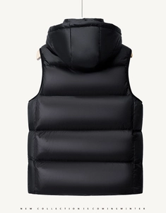 Detail of a black quilted down vest with a large hood on a wooden hanger background