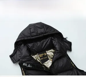 Detail of black hooded down vest featuring gold honeycomb heat-reflective lining
