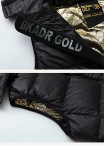 Detail of black puffer vest featuring a unique gold honeycomb thermal lining and BKADR logo