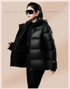 Detail of black puffer jacket showing premium gold letter branding on the sleeve cuff