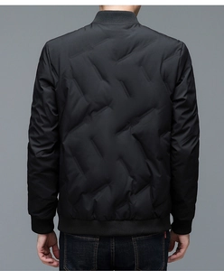 Detail of men's black quilted jacket with geometric padding and ribbed windproof cuffs