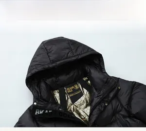 Detail der schwarzen Daunenjacke mit goldenem Wabenfutter und hochwertigem Webband