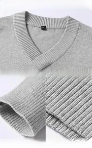 Detailed views of the V-neck, ribbed cuffs, and hem of this grey knitted cotton sweater