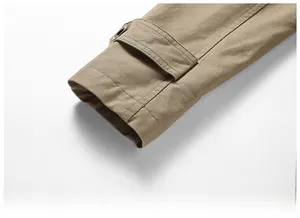 Détail du poignet d'une veste en coton kaki avec sangle réglable et œillet métallique