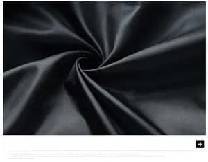 Macro detail of high-quality black down jacket fabric with fine twill texture and silky gloss