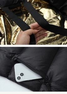 Detail view of premium black puffer jacket showing gold honeycomb lining and inner phone pocket