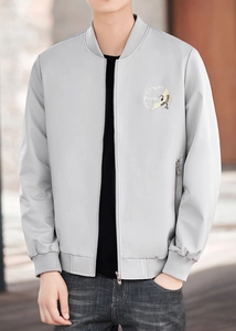 Macro shot of the detailed crane embroidery on a light gray bomber jacket chest