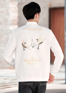 Detailed embroidery of flying cranes and artistic lettering on the back of a white jacket