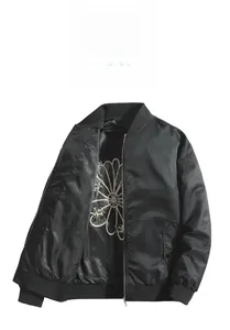 Detail of black satin baseball jacket showing white floral lining and ribbed collar trim