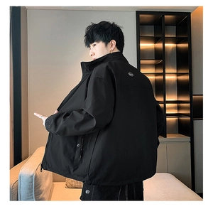 Detail view of the black jacket's stand collar and brand patch on the back shoulder